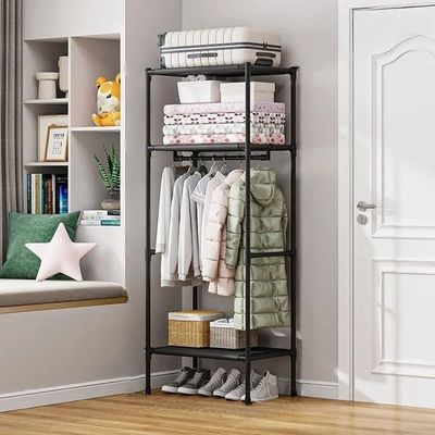 Penderie-avec-une tringle-et-trois-étagères-en-métal-présentant-des-vêtements-des-serviettes-une-valise-et-des-chaussures