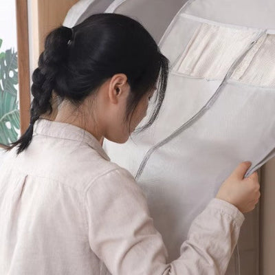 femme tient entre ses 2 mains housse dressing gris