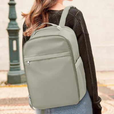 sac a dos voyage gris porte femme dans la rue