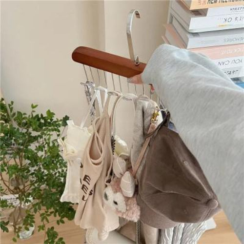 Cintre soutien-gorge en bois acajou une femme tient le cintre où sont accroches soutien gorge top à bretelle bijoux écharpe casquette