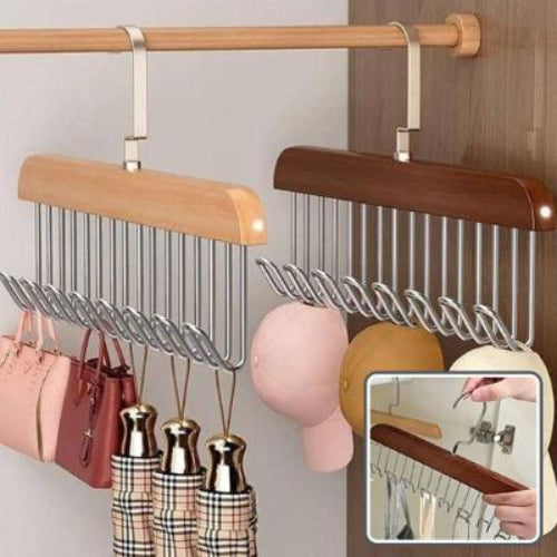 Cintre soutien gorge en bois accroché à une penderie avec suspendu dessus des parapluies des sac à main des casquettes