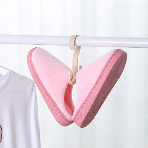 Crochet cintre beige avec des chaussons femme rose accrochés dessus