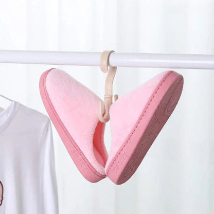 Crochet cintre beige avec des chaussons femme rose accrochés dessus