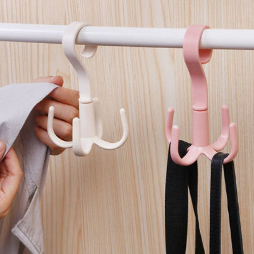 Crochet cintre blanc et rose en pvc prémium suspendu dans une penderie une main est entrain d'accrocher une veste