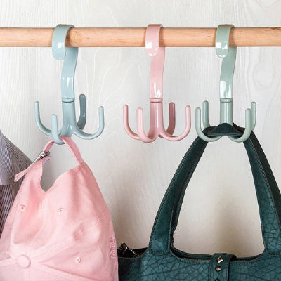 Crochet-cintre-bleu-rose-et-vert-avec- une-anse-de-sac-à-main-noir- accroché-dans-une-penderie-et-une- casquette-rose-accrochée