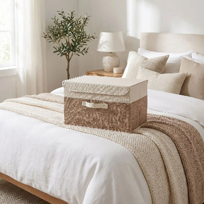 boite de rangement pour vetement posée sur lit