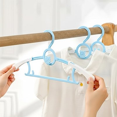 cintre enfant bleu tenu par les 2 extrémité par femme