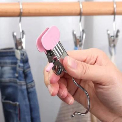 cintres a pinces rose tenue par une main de femme près d'une penderie avec des vêtements d'enfants