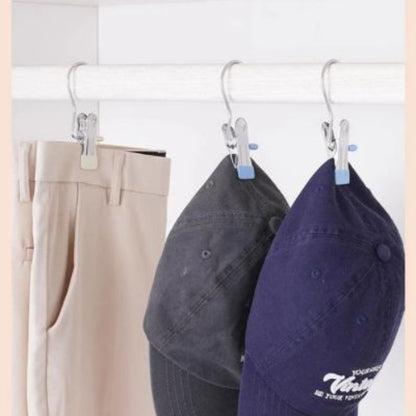 cintres a pinces bleu accroche sur une penderie qui tient des pantalons et des casquettes