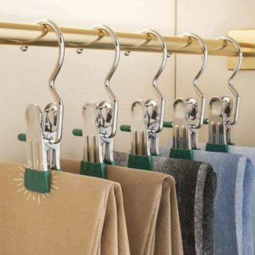 cintres a pinces vert accroche sur une penderie qui tient des pantalons et des jeans