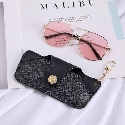 étui à lunette fermé noir posé sur magazine