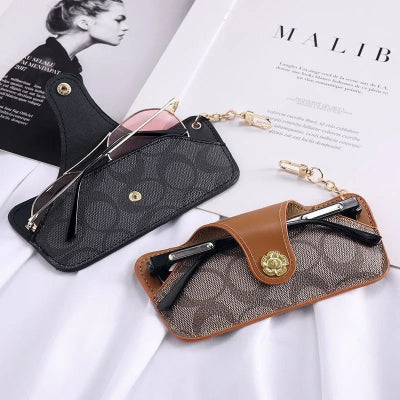 étui à lunette marron et noir posé sur magazine