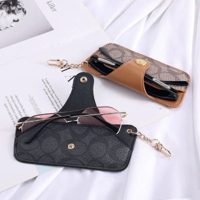 étui à lunette universel marron et noir posé sur magazine