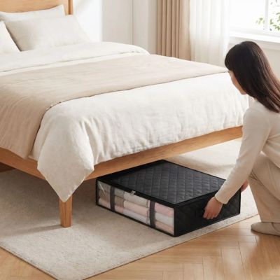 femme glisse sac de rangement pour vetement sous le lit