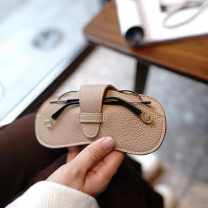 femme tient étui à lunettes beige