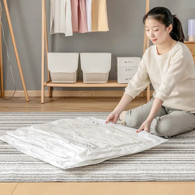 femme tient sac vetement sous vide portant vetement chevet chambre