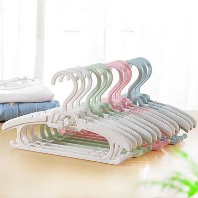lot de cintre enfant blanc vert rose aligné sur table