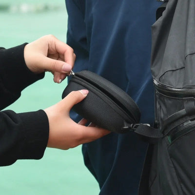 main ferme étui à lunette accroché sac à dos