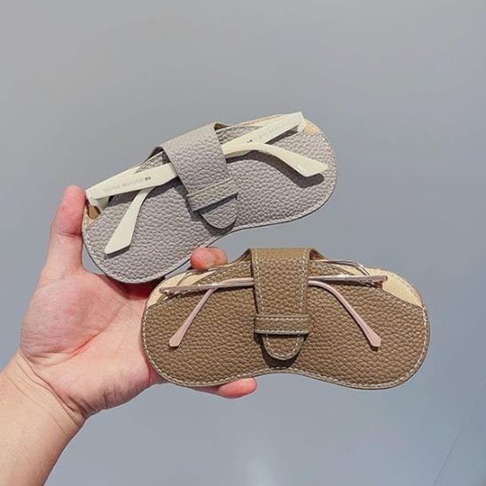 main tient étui à lunettes beige et marron