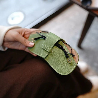 main tient étui à lunettes vert clair