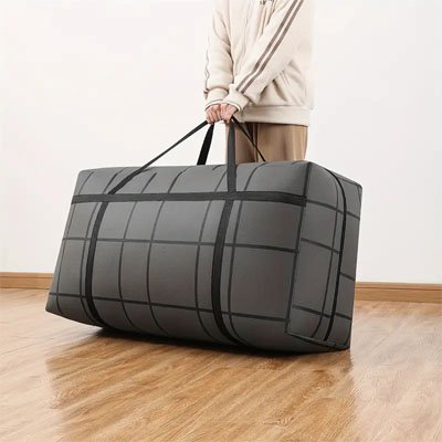 sac de rangement rempli tenu par poignee par un homme