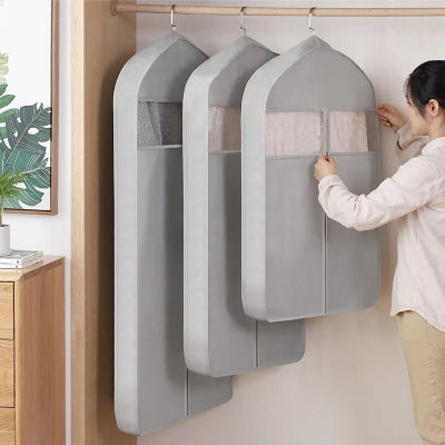 trois housses design alignées dans le penderie femme ouvre l'une d'entre elles